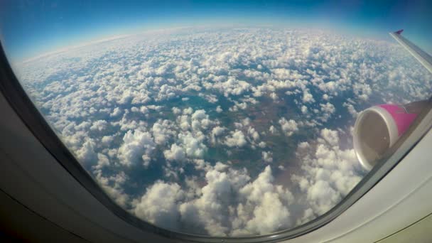 Flauschige Wolken aus Flugzeugfenstern, Flügel und Turbine im Schuss, niedrige Kosten — Stockvideo