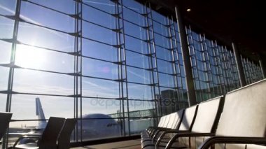 Güneşli Havaalanı terminal, uçak ayakta pencerenin arkasında, yatılı boş sandalyeler