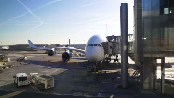 Avião de pé com ponte de jato conectado a ele, passageiros saindo do avião — Vídeo de Stock