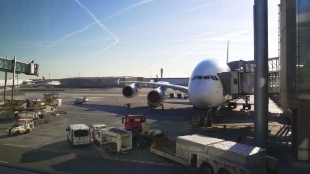 Avión grande parado cerca del puente aéreo, coche del aeropuerto que llega, soporte técnico — Vídeo de stock
