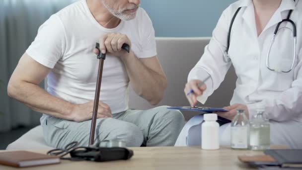 Therapeutin verschreibt alten Mann Medikamente, Menschen sitzen zu Hause auf Sofa — Stockvideo