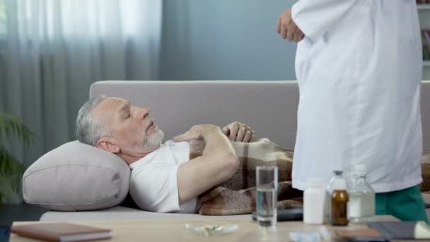 Pessoa idosa deitada na cama e reclamando médico de dor cardíaca. Serviços de saúde — Vídeo de Stock