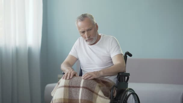 Hombre mayor paralítico en silla de ruedas no muestra reacción al empleado del asilo de ancianos — Vídeos de Stock