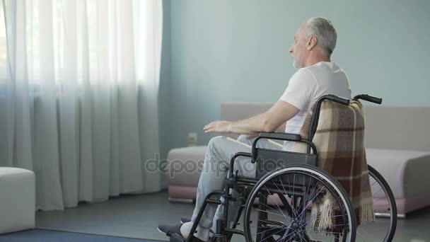 Triste vieillard solitaire triste assis en fauteuil roulant dans sa salle de soins infirmiers — Video