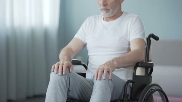Hombre indefenso con discapacidades sentado en silla de ruedas, volviendo a la cámara — Vídeo de stock
