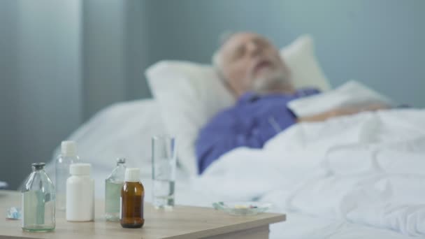 Terminally ill man taking painkillers and sleeping in hospital ward, suffering — Stock Video