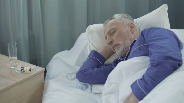 Paciente do sexo masculino cochilando na enfermaria do hospital, vendo sonhos e conversando em sono — Vídeo de Stock