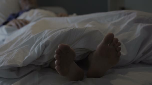 Sleeping man scratching his feet, nasty smell and discomfort due to foot fungus — Stock Video