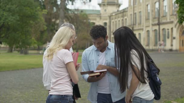 Professor de geografia sênior conversando com alunos perto da faculdade, explicando tópico — Vídeo de Stock