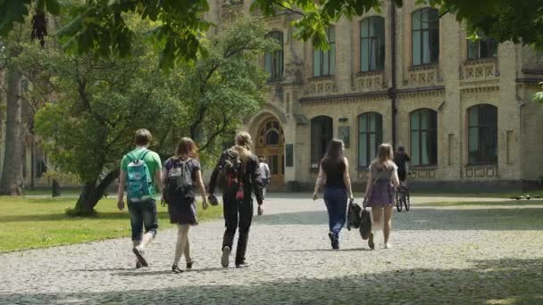 Изучает жизнь, юношей и девушек, гуляющих по университетскому кампусу, образование — стоковое видео
