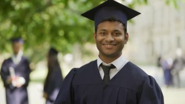 Akademik elbise ve gösterilen diploma ve başparmak-up, eğitim kap içinde mezun