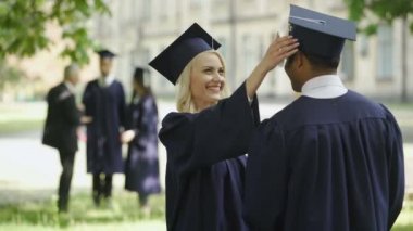 Lisansüstü kız öğrencinin söz erkek mezunu, dokunaklı şapka, mutlu arkadaşlar