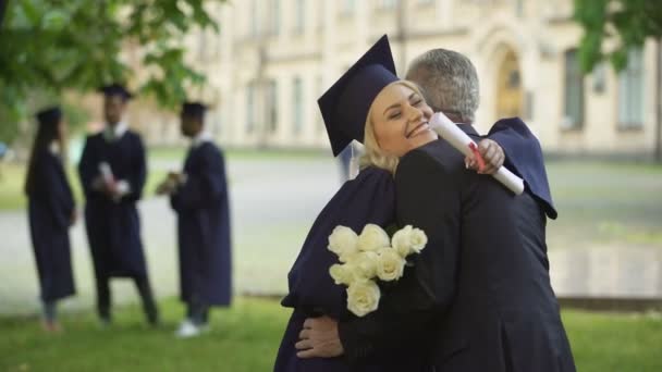 Ojciec daje kwiaty do córki absolwent, gratulacje, rodzicielskiej dumy — Wideo stockowe