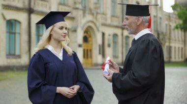 Üniversite diploması veren el, başlama sallayarak öğrenci için Başbakanı