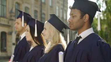 Sırada bekleyen ve konuşma için dinleme akademik regalia içinde yüksek lisans öğrencileri