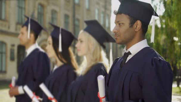 Karışık ırk Lisansüstü Öğrenci değişim programı kameraya gülümseyen diploması ile — Stok video