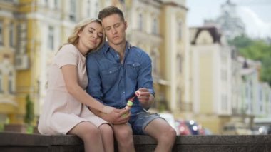 Kaygısız çift yan yana oturan kız kabarcıklar, mutlu insanlar üfleme