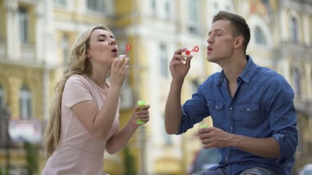 Freundin und Freund machen Seifenblasen und küssen, süße Beziehung — Stockvideo