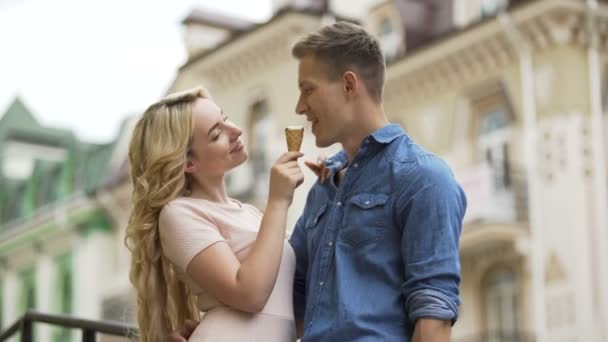 Novio y novia comiendo helado juntos, riendo, humor juguetón — Vídeo de stock