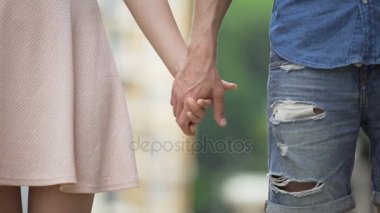 Genç kadın ve erkek birbirlerini el ile alarak ve salıverme, güle güle demek