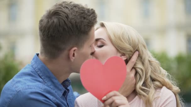 Bacio di coppia, ragazza che mette il cuore di carta, giovani innamorati, romantico — Video Stock