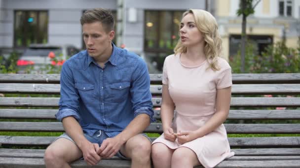 Boyfriend and girlfriend sitting on bench, girl slapping guy on face and leaving — Stock Video