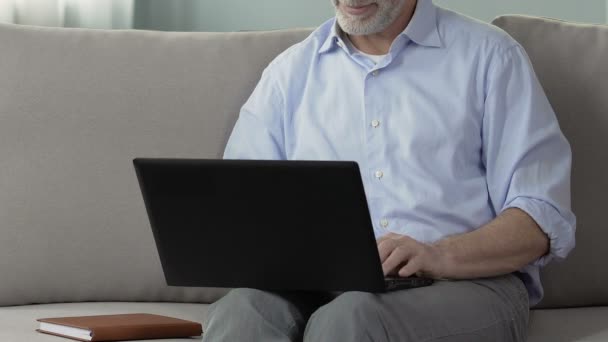 Hombre de pelo gris usando el ordenador portátil, comunicación en línea, servicio en línea de la búsqueda de la novia — Vídeo de stock