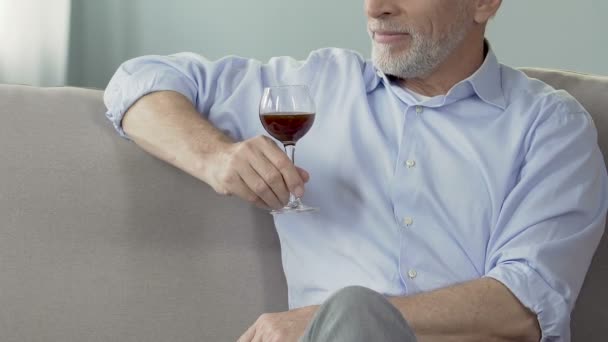 Homme âgé assis sur un canapé avec un verre de vin, profiter du moment, cave privée — Video