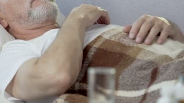 Üst düzey erkek önde, cam ile yatakta yalan uyku, ilaç sorunlu