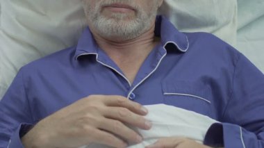 Yaşlı erkek yatakta yatan ve uyku, sakince, kesintisiz uyku nefes