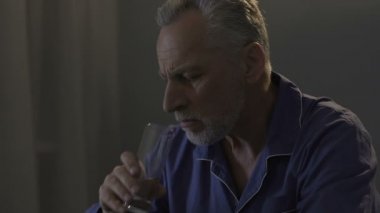 Karanlık oda ve alarak ilaç, oturma sakallı yaşlı adam sıkıyor uyku ile