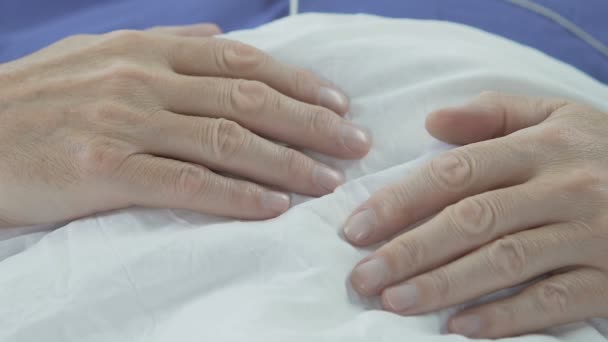 Händerna på äldre mannen liggande på mage, senior hane sovande, har resten i sängen — Stockvideo