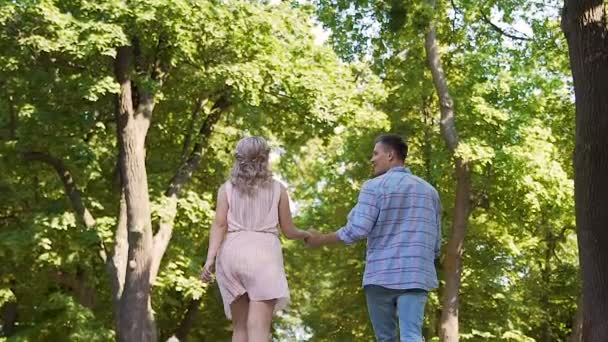 公園で手をつないで恋のロマンチックな気分で日付を楽しんで幸せな学生 — ストック動画