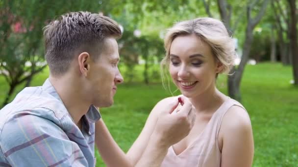 Улыбающаяся влюбленная пара веселится на романтическом пикнике в летнем парке, медленное время — стоковое видео