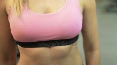 Sportif kadın egzersiz spor salonunda, aktif yaşam başlamadan önce akıllı saatini ayarlama