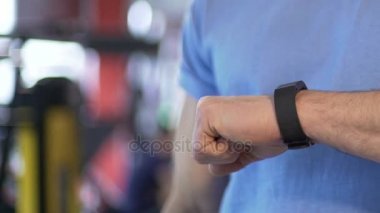 Antrenmandan önce eşitleme cep telefonu spor salonunda akıllı saat takan adam