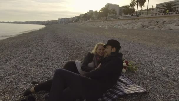 若いカップルのビーチで横になっていると、女の愛情のある関係の男をキスの話 — ストック動画