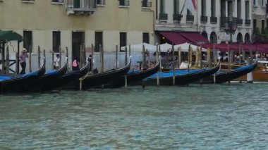 İnsanlarla birlikte yürüyüş yakınındaki banka direkleri için sallanan gondol satır demirleyen