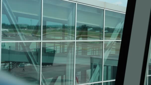 GDANSK, POLÓNIA - CIRCA AGOSTO 2014: Passeios turísticos na cidade. Avião se movendo através da pista após a aterrissagem, reflexão na janela do terminal — Vídeo de Stock