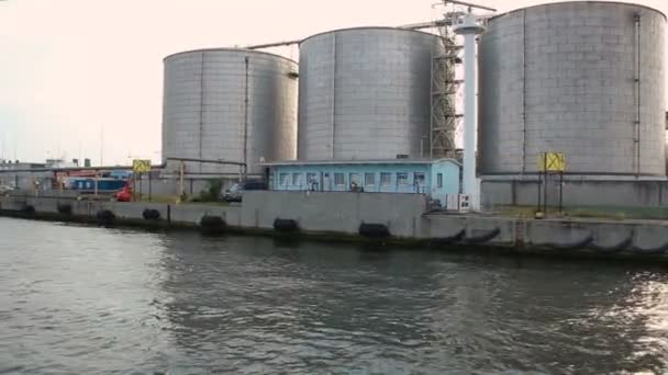 Uitzicht vanaf zee bij industriële pakhuizen met bijlage gebouwen in maritieme haven — Stockvideo