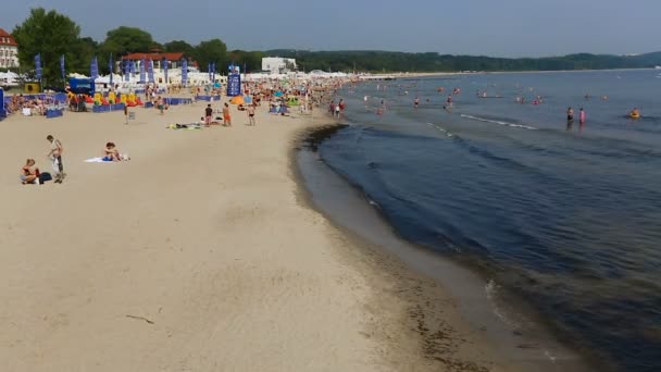 Горячий летний пляжный сезон в самом разгаре, люди отдыхают на пляже, последовательность — стоковое видео