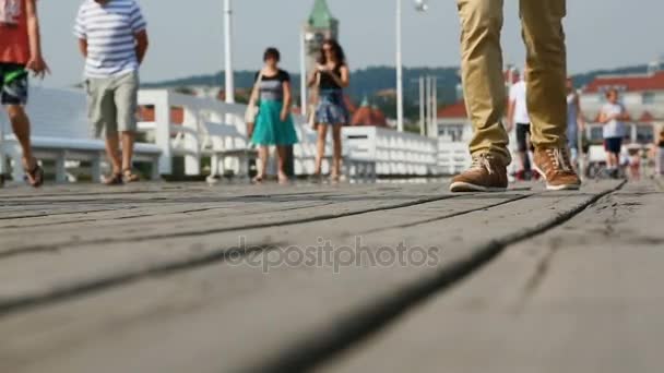 Passeggiate di persone passeggiando lungo il vecchio molo di legno, godendo della bellezza del mare — Video Stock