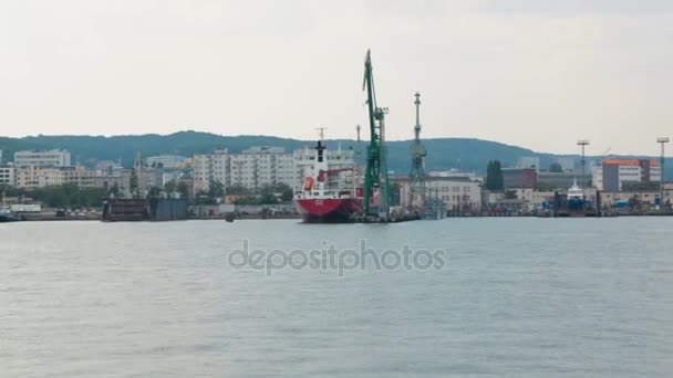 Промышленная зона приморского города с кранами и грузовыми судами, вид с моря — стоковое видео