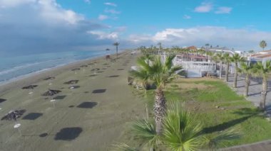 Hasır plaj şemsiyeleri ve Larnaka kafelerde güzel boş Beach havadan görünümü