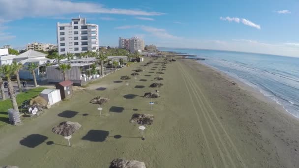 Vista fresca en la playa vacía con palmeras en la ciudad de Larnaca, Chipre, plano aéreo — Vídeos de Stock