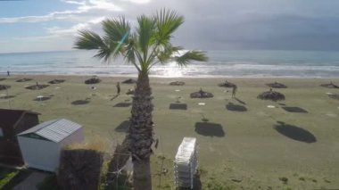 İki adam saman şemsiye ile sahilde tatil Larnaka güneşlenme
