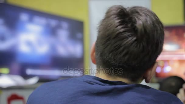 Joven hombre eligiendo el videojuego, mirando a la pantalla de televisión, tiempo libre y hobby — Vídeo de stock