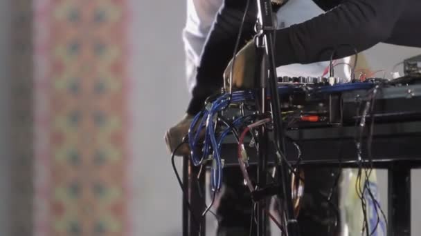 Hands of sound engineer connecting wires into dj's mixer, music equipment — Stock Video