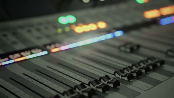 Lighting buttons, adjusting knobs and faders on expensive audio mixing console — Stock Video