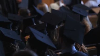 Üniversitesi Salonu'nda tören oturan akademik elbiseler giyen gençler